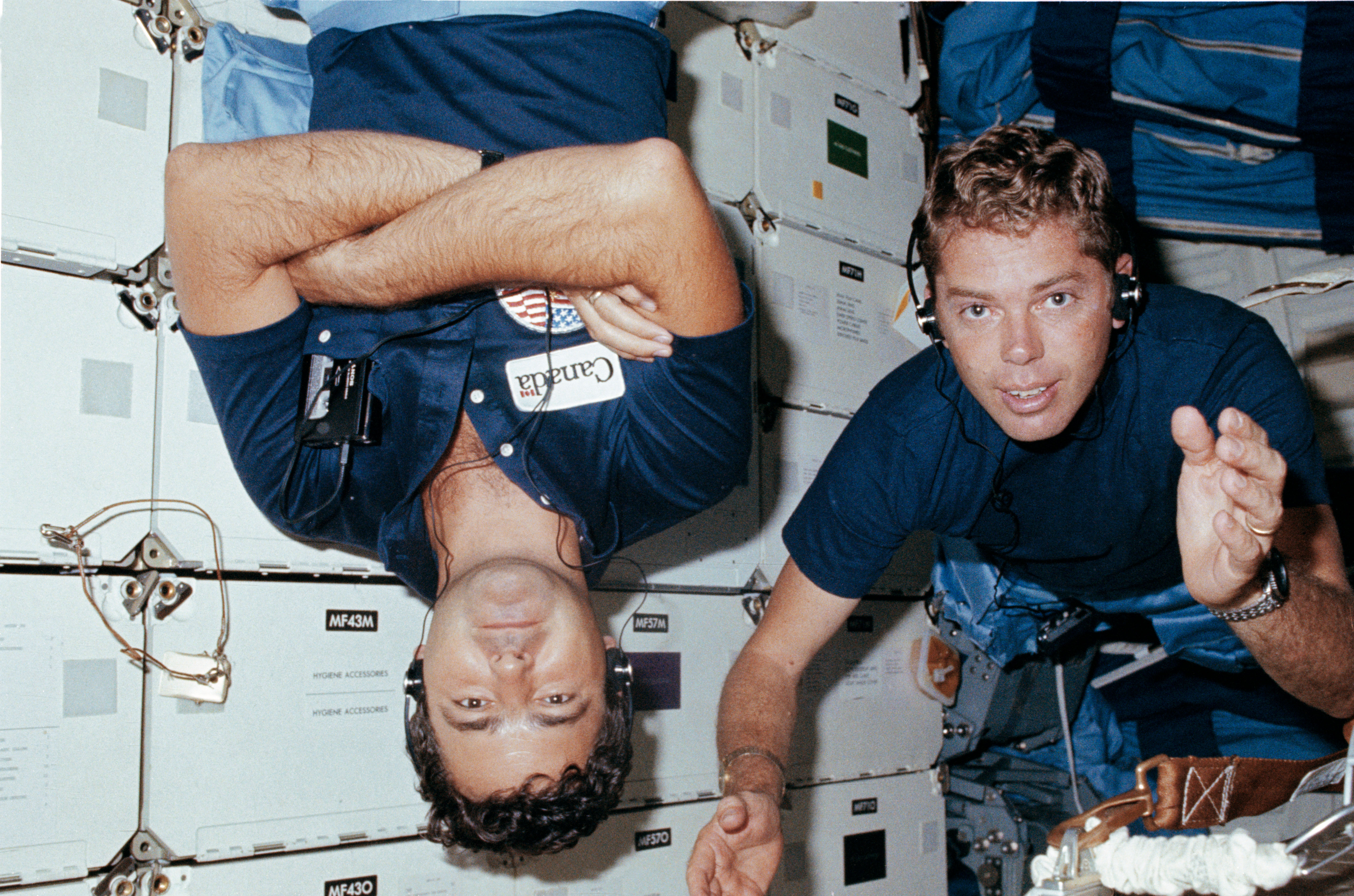 An 'upside down' Marc Garneau and NASA astronaut David Leestma aboard STS-41G