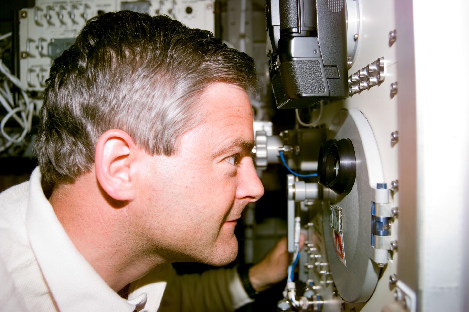 Marc Garneau observing proceedings in a furnace aboard STS-77 in 1996