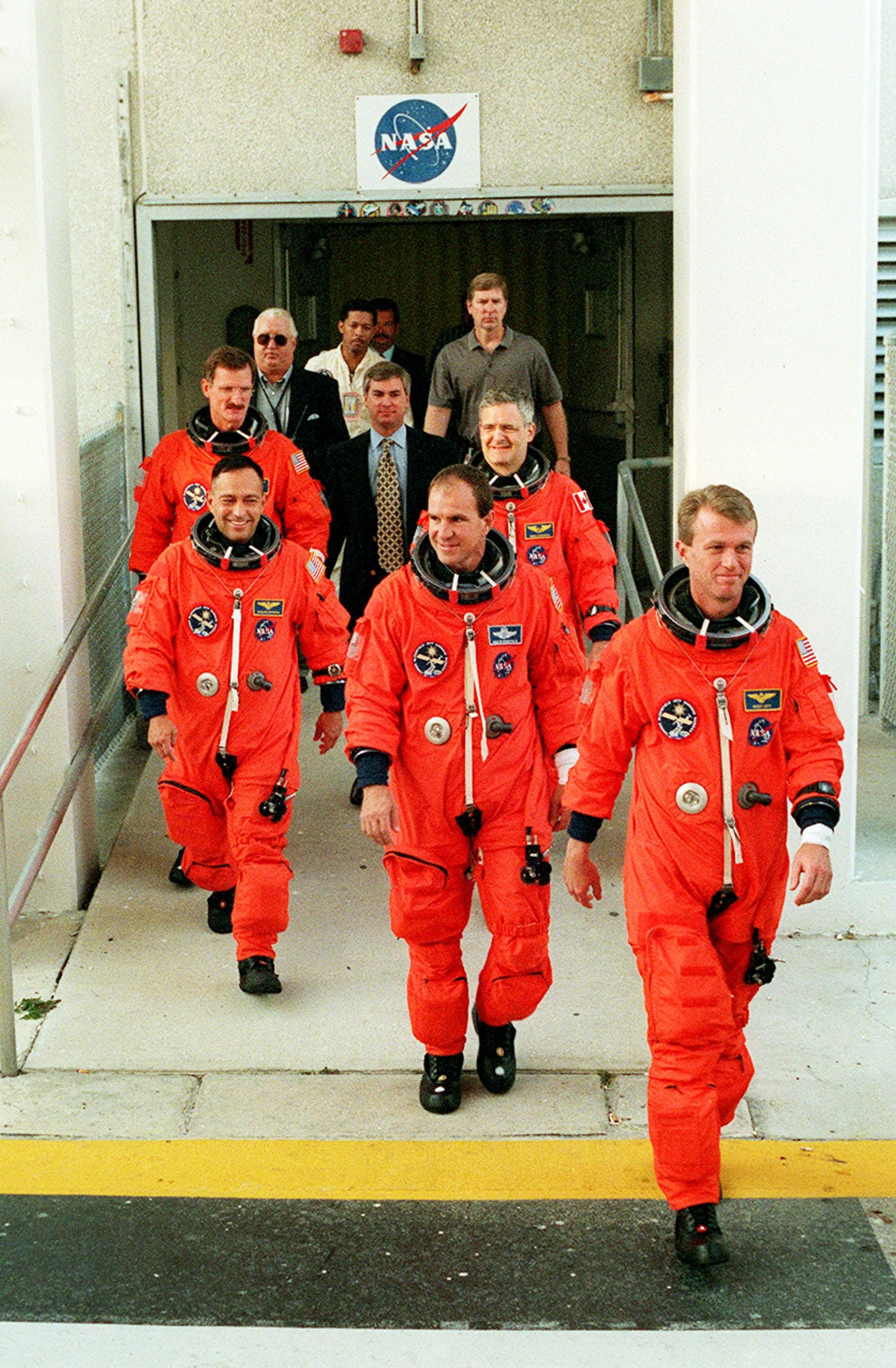 The STS-97 crew get a taste of the excitement of launch day as they exit the O&C Building to head for Launch Pad 39B. They are taking part in Terminal Countdown Demonstration Test (TCDT) activities that include emergency egress training and a simulated launch countdown. On the left (front to back) are Mission Specialists Carlos Noriega and Joe Tanner; on the right (front to back) are Commander Brent Jett, Pilot Mike Bloomfield and Mission Specialist Marc Garneau, who is a Canadian astronaut. Mission STS-97is the sixth construction flight to the International Space Station. Its payload includes the P6 Integrated Truss Structure and a photovoltaic (PV) module, with giant solar arrays that will provide power to the Station. The mission includes two spacewalks to complete the solar array connections. STS-97 is scheduled to launch Nov. 30 at 10:05 p.m. EST The STS-97 crew about to head to the launch pad for some final pre-launch testing for STS-97 in 2000