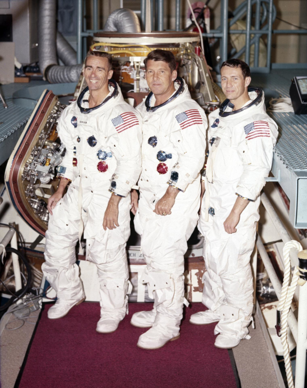 The Apollo 7 crew pose in their launch/entry spacesuits for a crew portrait during training