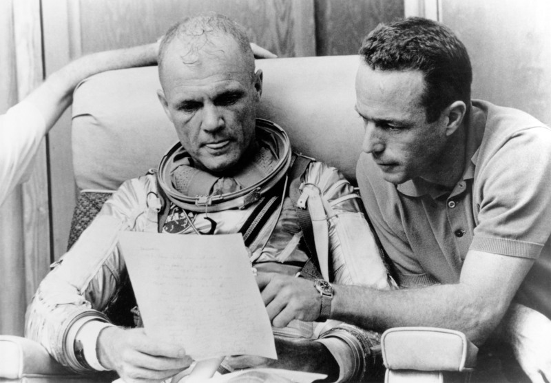 Glenn and Scott Carpenter read through some notes following a simulation exercise in training