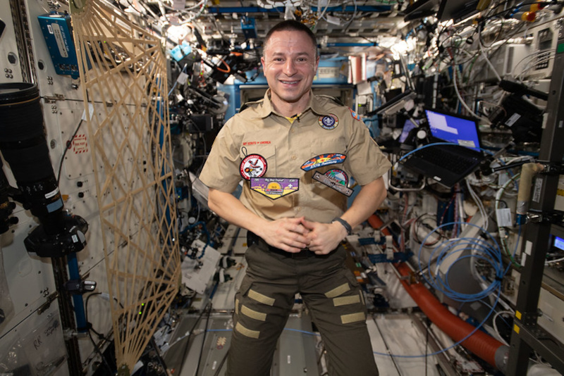 morgan is photographed in scout uniform aboard ISS to commemorate a 100th anniversary for the movement.